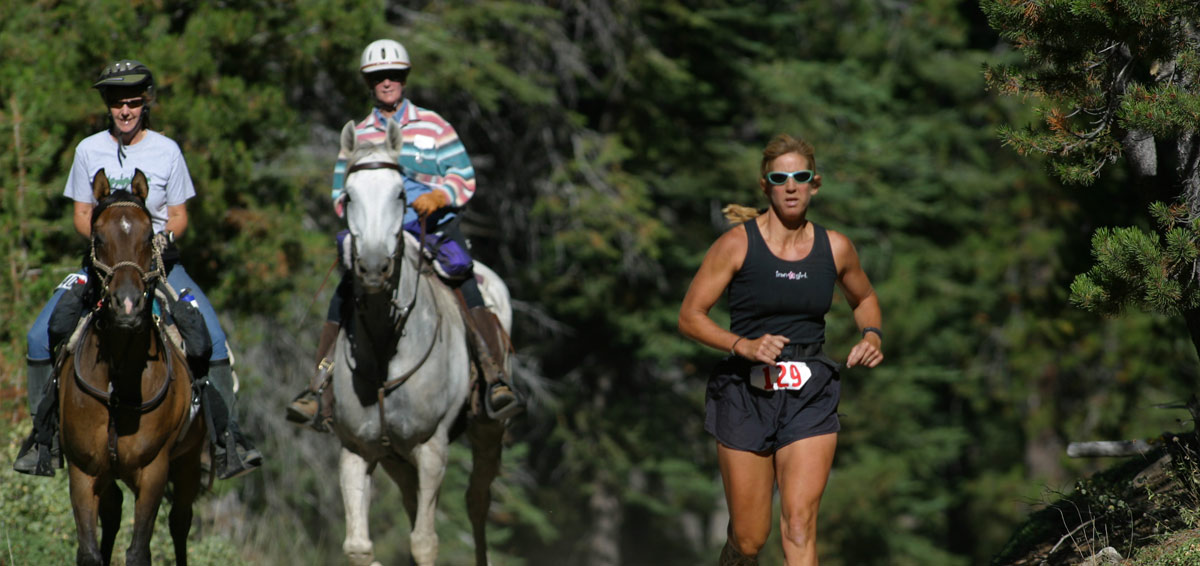 Image of two riders and one runner.