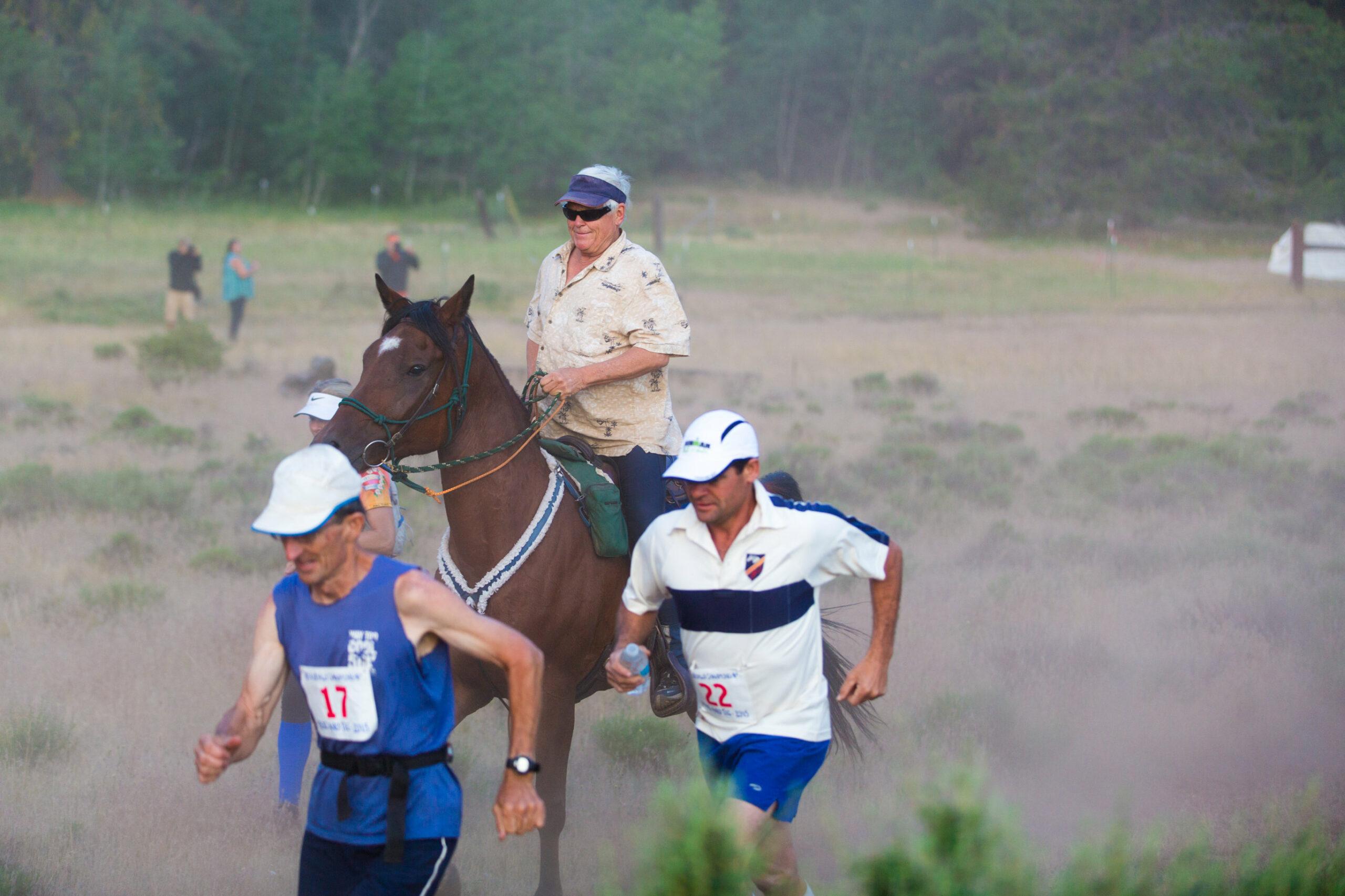 Image of a rider and two runners.